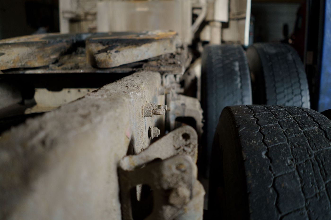 Close-up of a commercial trailer frame rail, hanger bracket and dual tires