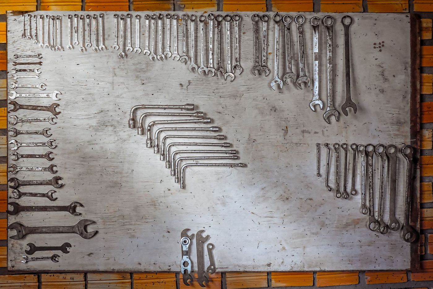 An organised board of wrenches laid out by size in a workshop
